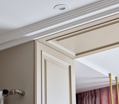 A sophisticated and elegant interior design that showcases intricate crown molding along with stylish lighting features